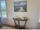 Console table with beach themed painting and decorations, complemented by ample natural light at 305 Matilda St, Edisto Beach, SC 29438