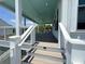 Inviting porch with elegant railings, steps, and a tranquil blue ceiling at 305 Matilda St, Edisto Beach, SC 29438