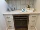 Stylish wet bar boasts built-in wine cooler, display space, and white cabinets, perfect for entertaining at 305 Matilda St, Edisto Beach, SC 29438