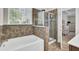 Elegant bathroom featuring a bathtub, separate glass shower, and tiled walls at 308 Legendres Dr, Goose Creek, SC 29445