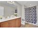 Cozy bathroom with warm wood cabinets, neutral walls, and a patterned shower curtain, adding a stylish touch at 308 Legendres Dr, Goose Creek, SC 29445