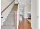 Bright entryway with hardwood floors, staircase with wood railing, and view into the living area at 308 Legendres Dr, Goose Creek, SC 29445
