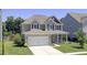 Charming two-story home featuring a welcoming front porch, manicured lawn, and attached two-car garage at 308 Legendres Dr, Goose Creek, SC 29445