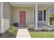 Inviting front porch with a red front door, white columns, and beautifully landscaped flower beds at 308 Legendres Dr, Goose Creek, SC 29445