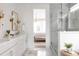 Bright bathroom featuring a double sink vanity, modern lighting, glass shower, and view into the bedroom at 3139 Vanessa Lynne Ln, Johns Island, SC 29455