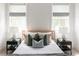 Bright bedroom featuring two windows with striped blinds, a striped throw blanket, and matching end tables with lamps at 3139 Vanessa Lynne Ln, Johns Island, SC 29455
