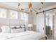Bright main bedroom featuring a bed with decorative pillows, modern lighting, and barn door to the bathroom at 3139 Vanessa Lynne Ln, Johns Island, SC 29455