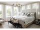 Sun-drenched primary bedroom featuring a decorative light fixture, large windows, and soft, neutral tones at 3139 Vanessa Lynne Ln, Johns Island, SC 29455