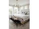 Sun-drenched primary bedroom featuring a decorative light fixture, large windows, and soft, neutral tones at 3139 Vanessa Lynne Ln, Johns Island, SC 29455