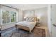 Inviting bedroom featuring wood floors, a large window, wood-framed bed, and stylish light fixture at 3143 Vanessa Lynne Ln, Johns Island, SC 29455