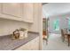 Butler's pantry leading to the dining room with granite countertops and white cabinetry at 3331 Cottonfield Dr, Mount Pleasant, SC 29466