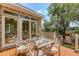 Charming outdoor patio area with a glass-top table, seating, a wooden deck, and lush foliage at 3331 Cottonfield Dr, Mount Pleasant, SC 29466