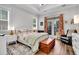 Bright bedroom with tray ceilings, hardwood floors, bench, and door to the backyard at 3529 Habenaria Rd # 33, Mount Pleasant, SC 29466
