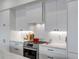 A modern kitchen has stainless steel appliances, a red dutch oven, and tiled backsplash at 405 Spartina Ln # 405, Charleston, SC 29492