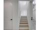 Modern staircase with wooden steps, white risers, and a glass door leading to the outside at 405 Spartina Ln # 405, Charleston, SC 29492
