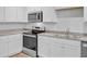 Close-up of kitchen with stainless steel appliances and white cabinetry with gray countertops at 407 Spruce Ivy St, Moncks Corner, SC 29461