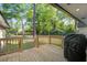 Back porch with wood railing and steps offers a view of the large, private backyard and greenery at 408 N Palmetto St, Summerville, SC 29483