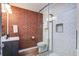 This bathroom features a brick wall, updated fixtures, and new tiling in the shower area at 408 N Palmetto St, Summerville, SC 29483