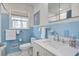 Classic blue bathroom with a marble countertop sink, tiled walls, and stylish fixtures at 408 N Palmetto St, Summerville, SC 29483
