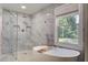 Luxurious bathroom featuring a freestanding tub, a glass-enclosed shower, and marble flooring at 408 N Palmetto St, Summerville, SC 29483