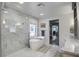 Modern bathroom featuring a freestanding tub, a glass shower, and marble tile, creating a luxurious spa-like retreat at 408 N Palmetto St, Summerville, SC 29483