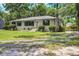 Charming painted brick home surrounded by lush greenery, offering a serene and inviting curb appeal at 408 N Palmetto St, Summerville, SC 29483