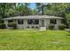 Charming single-story home featuring a well-manicured lawn and a classic brick facade at 408 N Palmetto St, Summerville, SC 29483