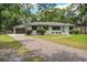 Beautiful home with a white-painted brick exterior, black window shutters, and a gravel driveway at 408 N Palmetto St, Summerville, SC 29483