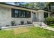 Charming brick home featuring black shutters, a light blue front door, and fresh landscaping at 408 N Palmetto St, Summerville, SC 29483