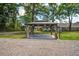 Outdoor gazebo with curtains, a concrete slab, and a view of the backyard and trees at 408 N Palmetto St, Summerville, SC 29483
