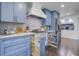 This renovated kitchen showcases blue cabinets, stainless steel appliances, and a decorative backsplash design at 408 N Palmetto St, Summerville, SC 29483