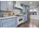 This renovated kitchen showcases blue cabinets, stainless steel appliances, and a decorative backsplash design at 408 N Palmetto St, Summerville, SC 29483