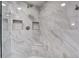 This modern shower features marble tiling, built-in shelves, and rainfall shower head at 408 N Palmetto St, Summerville, SC 29483