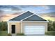 Single-story home showcasing a two-car garage and a neatly landscaped front yard with black front door and tan siding at 416 Mistflower Ln, Moncks Corner, SC 29461