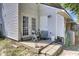 Outdoor patio area with white siding, double doors, a small table, and steps to the yard at 4662 Nibbs Ln, North Charleston, SC 29418