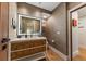 Bright bathroom features a vanity with decorative burl wood drawers and an illuminated mirror at 4943 Green Dolphin Way, Kiawah Island, SC 29455