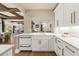 Well-lit kitchen showcasing sleek white cabinets, marble countertops, and elegant fixtures at 4943 Green Dolphin Way, Kiawah Island, SC 29455
