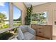Bright sunroom features marsh views, a striped chair, and elegant console with natural light at 4943 Green Dolphin Way, Kiawah Island, SC 29455