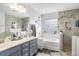 Bathroom with a double sink vanity, soaking tub, and walk-in shower featuring modern fixtures at 4987 Ballantine Dr, Summerville, SC 29485