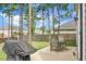 Outdoor space with patio table set and grill amid mature trees at 523 Kilarney Rd, Summerville, SC 29483