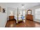Bedroom with dark hardwood floors, four poster bed, and dresser with mirror at 548 Sea Foam St, Summerville, SC 29486