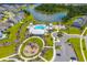 Aerial view of the community pool, clubhouse, and playground surrounded by landscaped greenery and homes at 627 Chigwell Springs Ln, Summerville, SC 29486