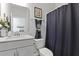 Bright bathroom with white vanity, toilet, and tub/shower featuring gray shower curtain for a clean, modern look at 627 Chigwell Springs Ln, Summerville, SC 29486