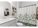 Cozy bathroom featuring a white vanity, toilet, and tub/shower, adorned with a decorative floral shower curtain at 627 Chigwell Springs Ln, Summerville, SC 29486