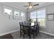 Cozy dining area with dark table, patterned rug, and natural light from multiple windows at 627 Chigwell Springs Ln, Summerville, SC 29486