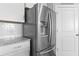 Stainless steel refrigerator in a white kitchen with granite countertops and white subway tile backsplash at 627 Chigwell Springs Ln, Summerville, SC 29486
