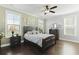Bright main bedroom with windows, ceiling fan, and dark wood furniture at 627 Chigwell Springs Ln, Summerville, SC 29486