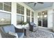 Relaxing screened-in patio with wicker chairs, decorative rug, and views of the tranquil backyard and interior dining area at 627 Chigwell Springs Ln, Summerville, SC 29486