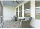 Relaxing screened-in patio with wicker chairs, decorative rug, and views of the tranquil backyard at 627 Chigwell Springs Ln, Summerville, SC 29486