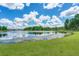 Scenic view of the lush community pond, with green shoreline and wooded areas in the background at 627 Chigwell Springs Ln, Summerville, SC 29486